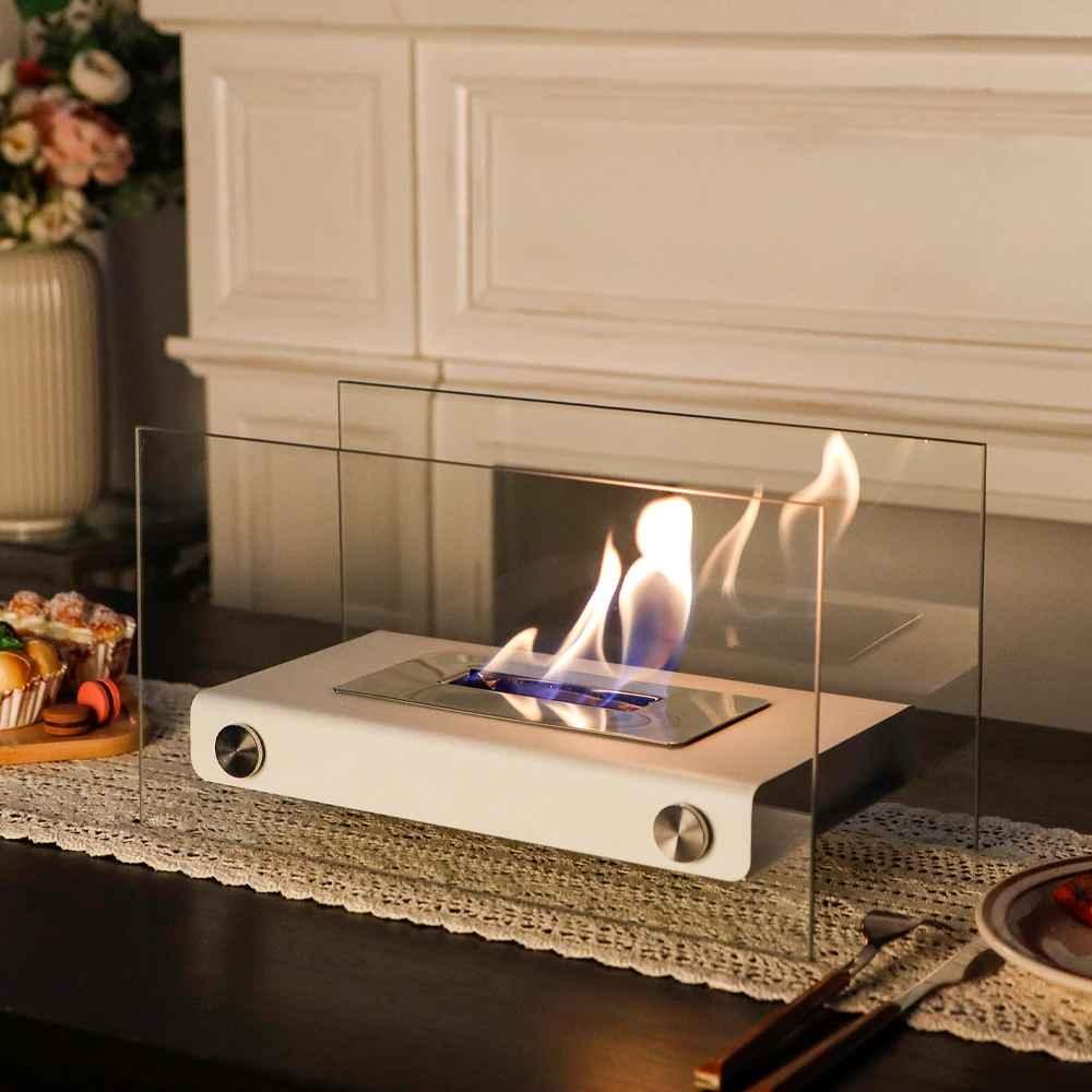 Modern tabletop ethanol fireplace with glass panels on a lace table runner indoors