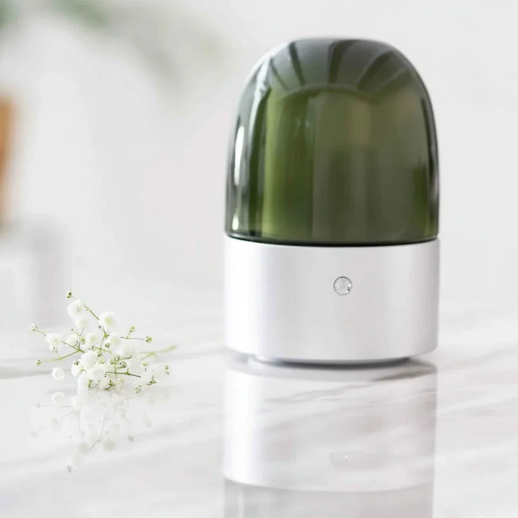 Green and white cylindrical device on a light surface with blurred background