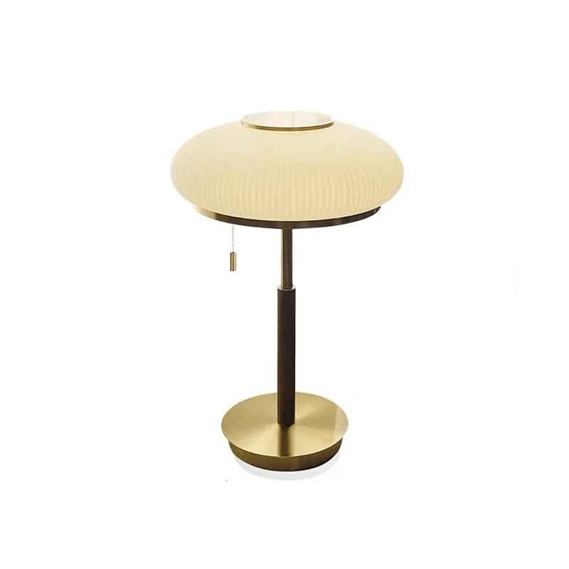Modern brass table lamp with round pleated shade on white background