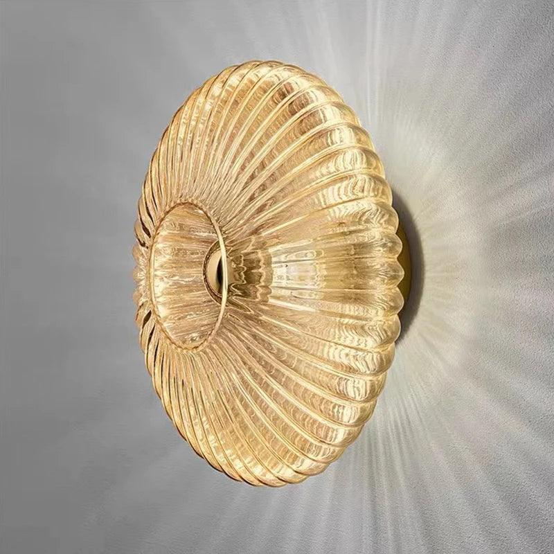 Modern glass wall sconce with ribbed golden design and warm ambient lighting