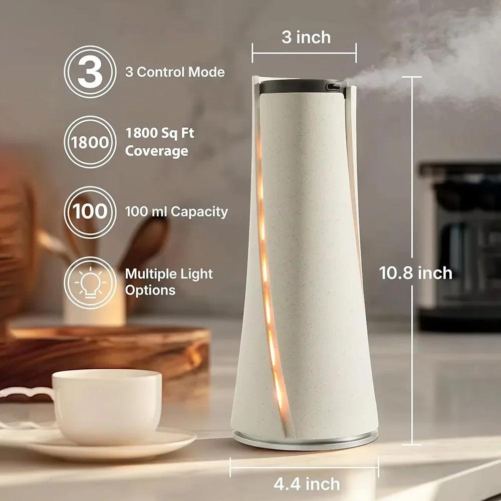 Modern white air diffuser with warm LED lights, 100ml capacity, 1800 sq ft coverage, on a kitchen countertop.