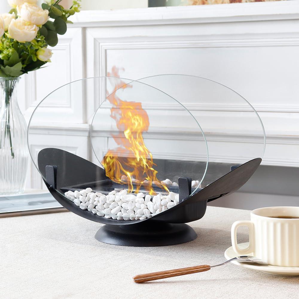 Modern tabletop glass fire pit with white stones, burning flame, and coffee cup nearby