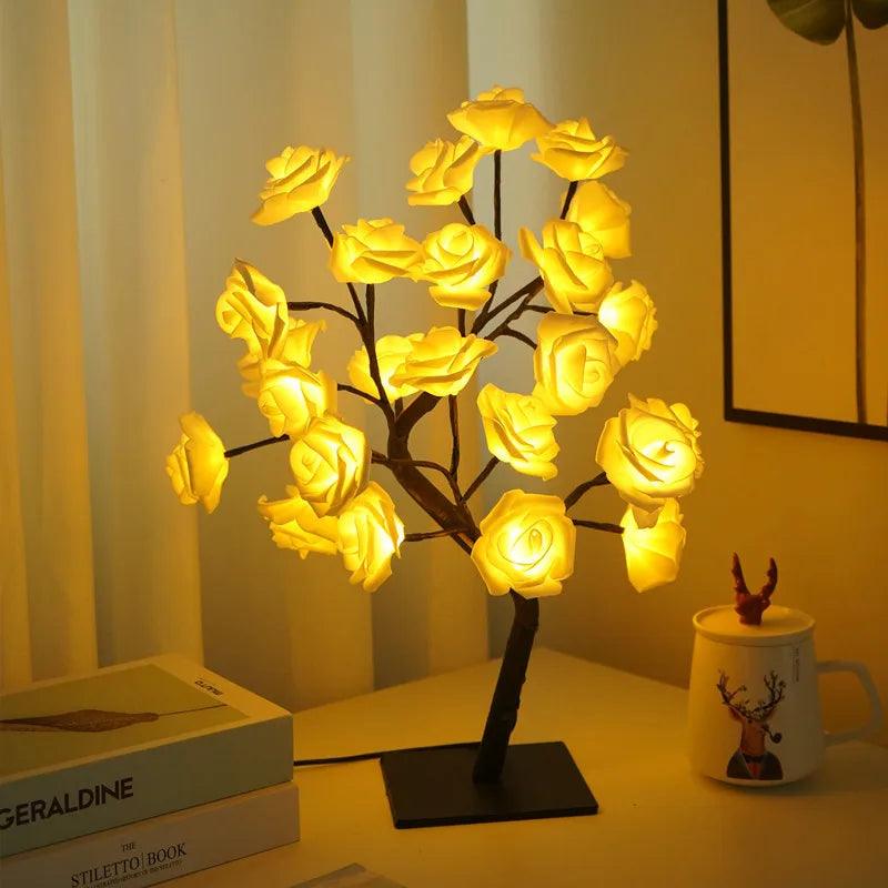LED rose flower table lamp glowing warmly on a desk near a mug and stacked books