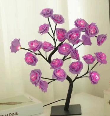 Purple LED rose flower tree lamp on a table near a white curtain, home decor lighting.