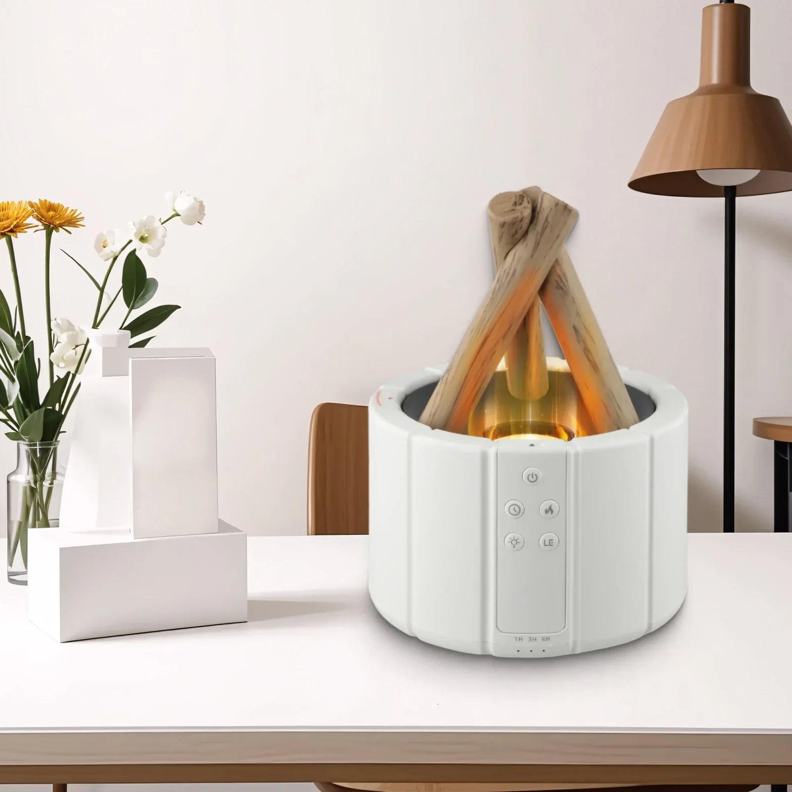 Modern tabletop faux fireplace heater with LED flame on white desk, vase with flowers beside it
