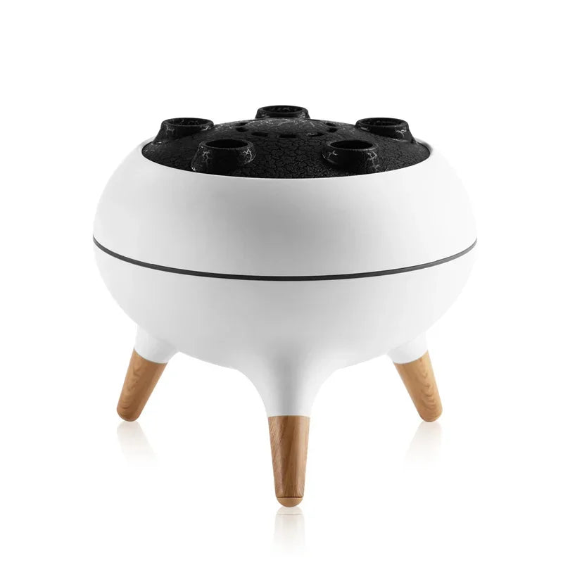 Modern tabletop charcoal grill with white round body, wooden legs, and black textured lid